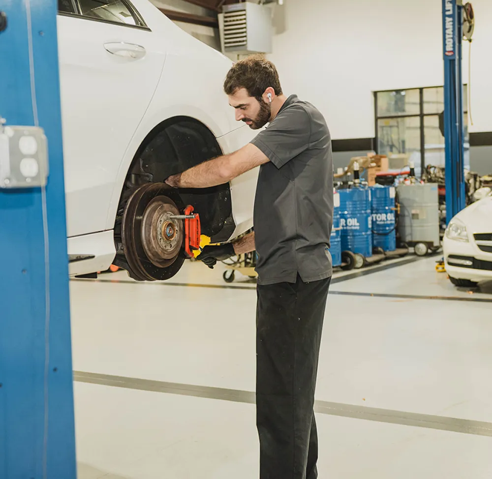 Mechanic working on car brake system for CW Performance in Apex, NC