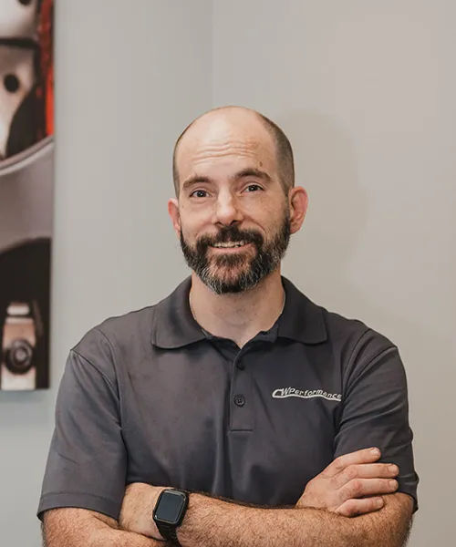 Man with beard, smiling, arms crossed.