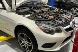 Mercedes-Benz engine repair in Apex, NC at CW Performance. Image of a white Mercedes with the hood open and service equipment connected in the engine bay for inspection and maintenance.